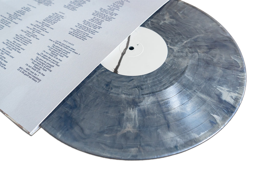A marbled grey and white Spite House Metallic Mercury Blend Vinyl LP is partially slid out from its sleeve, revealing printed song lyrics inside.