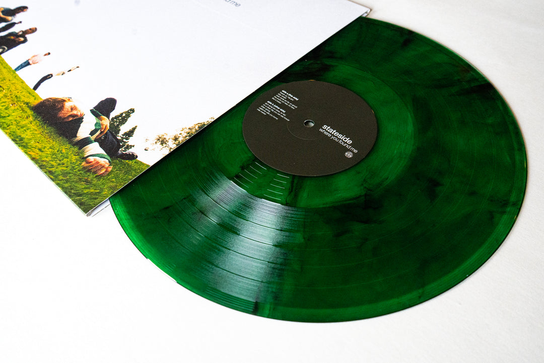 A Stateside Green Smoke Vinyl record partially slides out of its sleeve, which features a photo of people lying on grass under a blue sky.