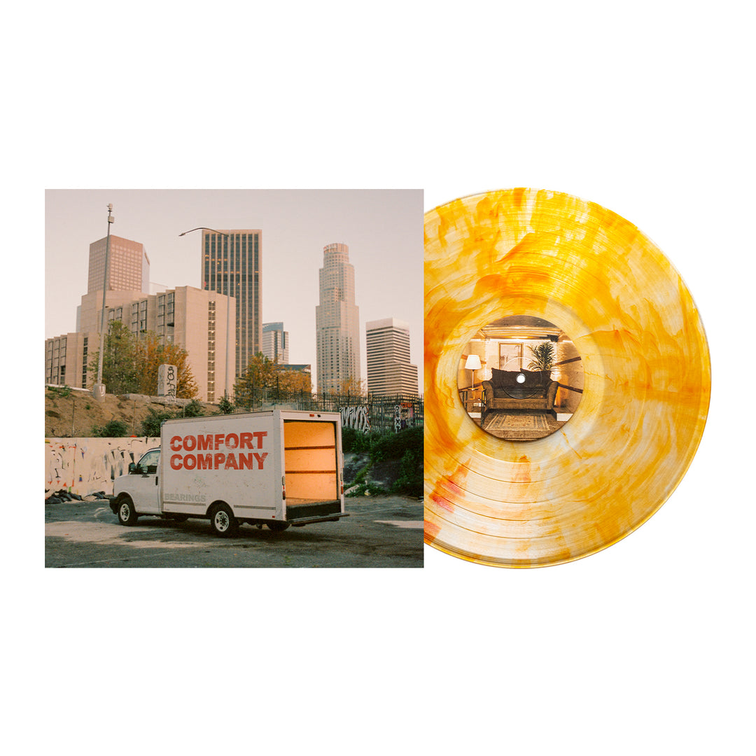 A Bearings Citrine Deluxe Vinyl, featuring a yellow-orange marbled pattern, is displayed beside an album cover with a moving truck in front of city buildings at sunset. Secure yours now with the Album Presale.