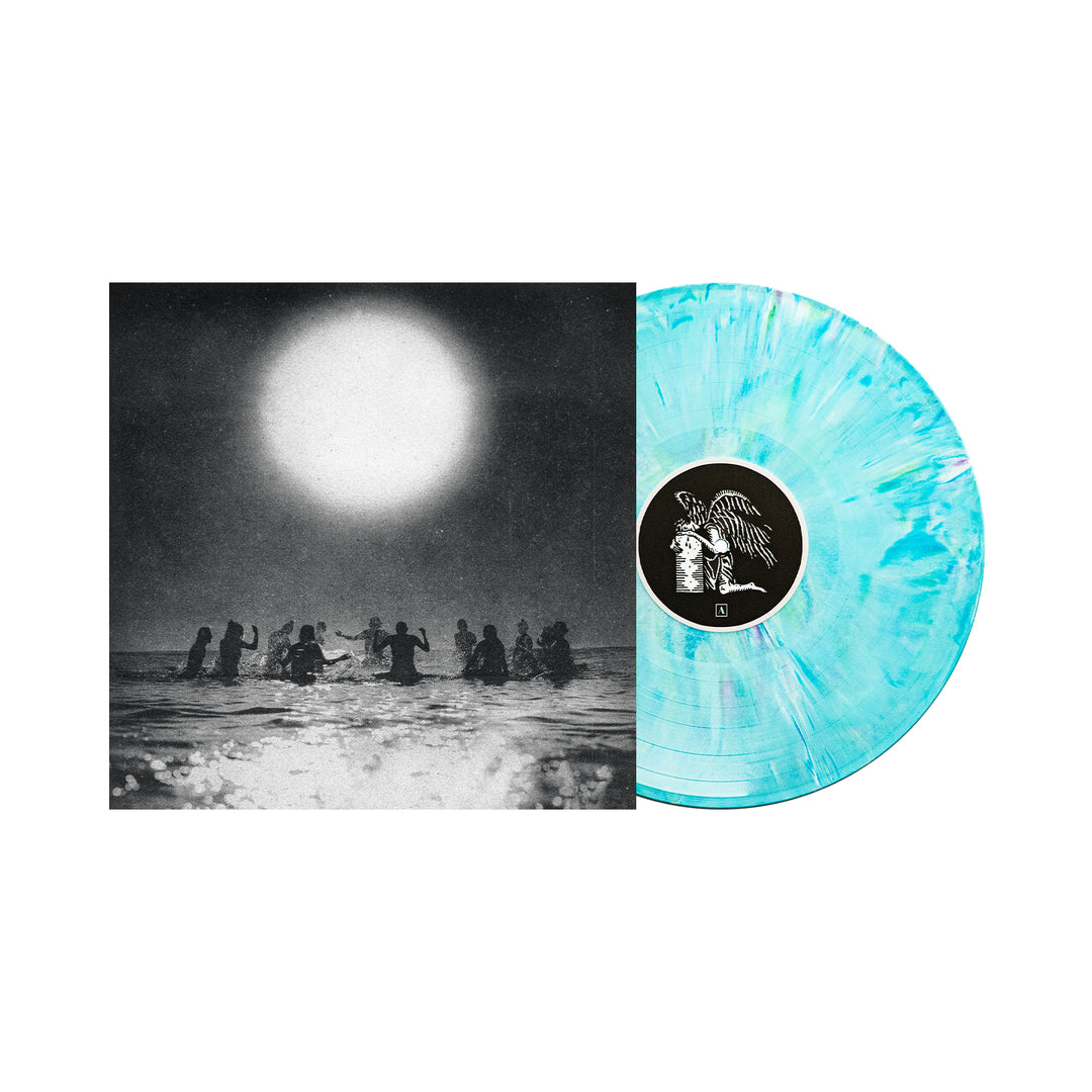 A turquoise and white marbled Seahaven vinyl partially slides out from its album cover, which features silhouetted figures standing in water beneath a large sun in a black-and-white scene.
