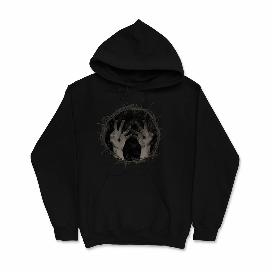 Black printed hoodie by Vomit Forth, featuring two hands reaching from a circular, thorny border on the chest—a bold custom apparel choice with an emerging effect.