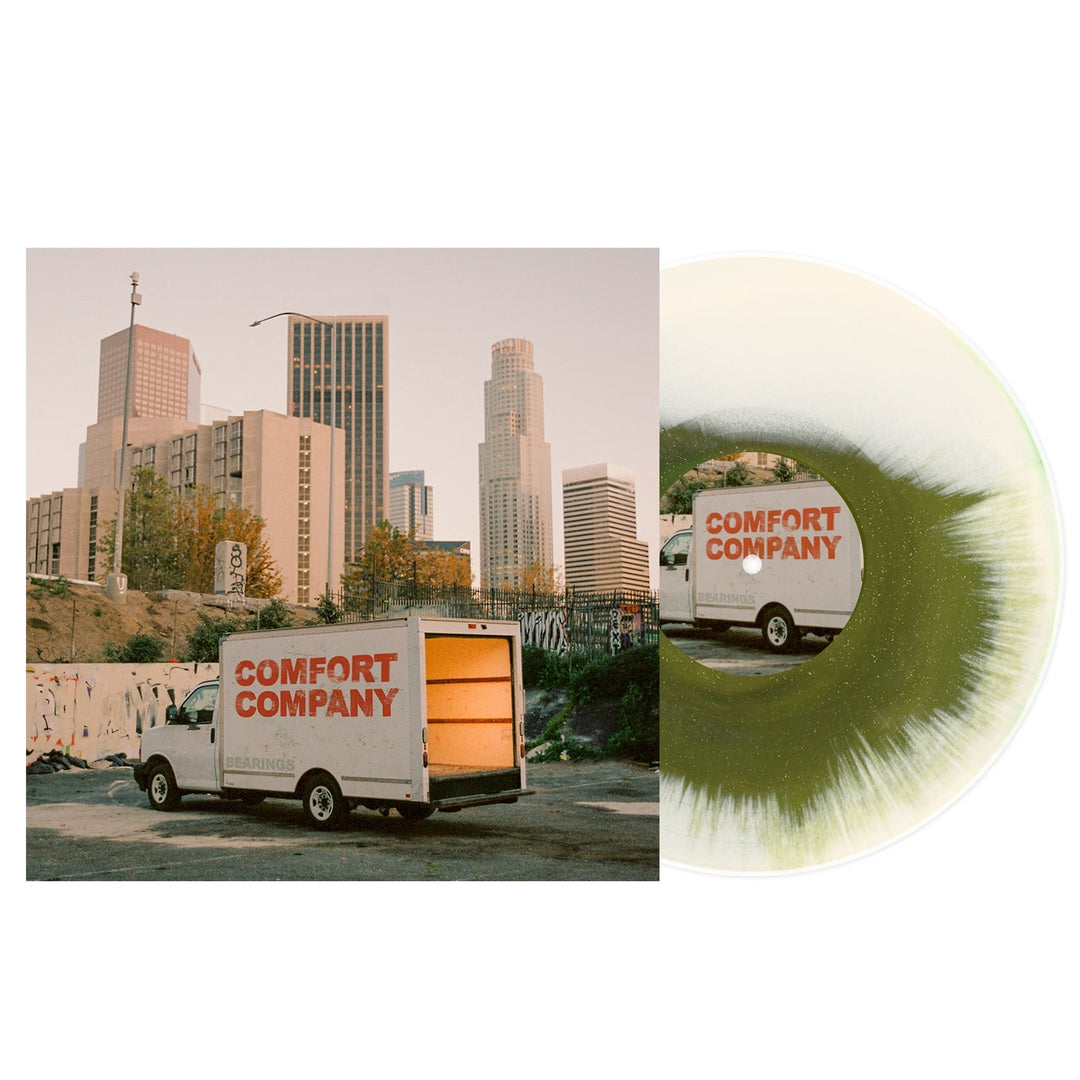 A white moving truck labeled Bearings is parked before downtown city buildings at sunset. Alongside the photo, a Swamp Green Vinyl record with a striking white and green pattern is partially visible.