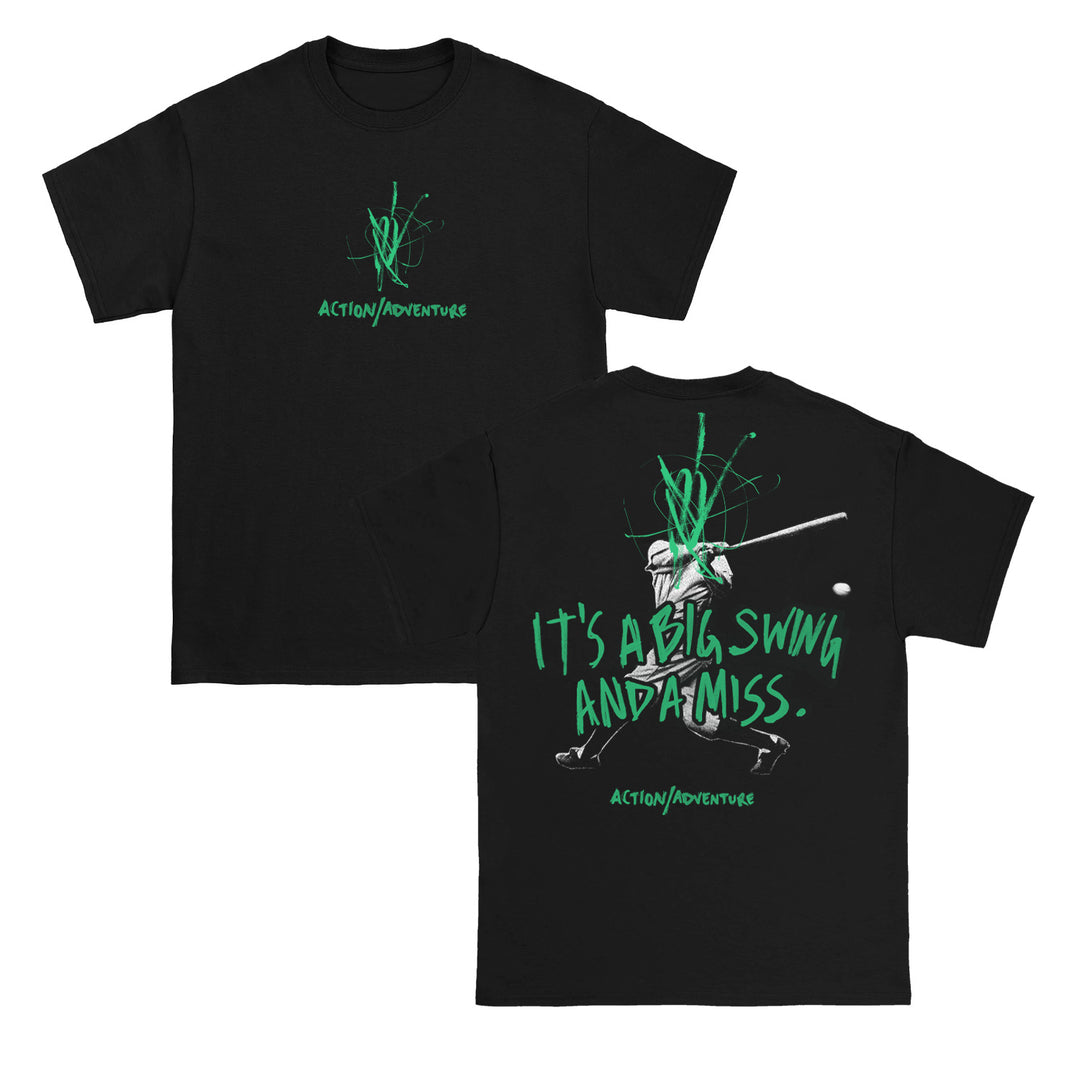 Action/Adventure black tee featuring a baseball batter swing graphic and green graffiti text. Back reads “ITS A BIG SWING AND A MISS.” above “ACTION/ADVENTURE.” Front has small green graffiti logo and brand name.