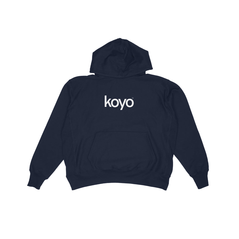 A KOYO navy blue hoodie lays flat with "KOYO" in white on the upper back. Featuring a front pocket, hood, and timeless style, it's a classic piece for your everyday rotation.