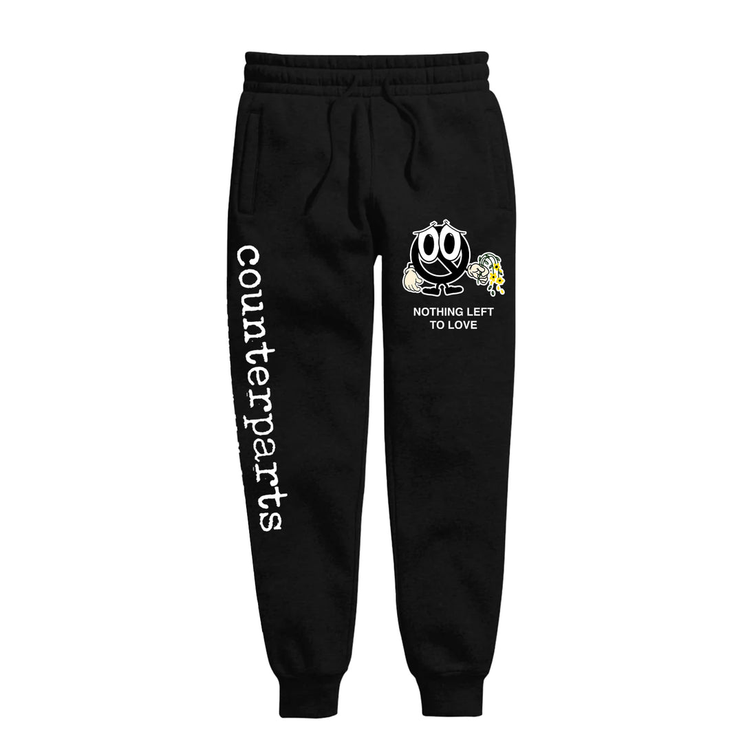 Black sweatpants by Counterparts featuring "counterparts" printed vertically on the left leg and a cartoon sad face holding a wilted flower above "NOTHING LEFT TO LOVE" on the right thigh.