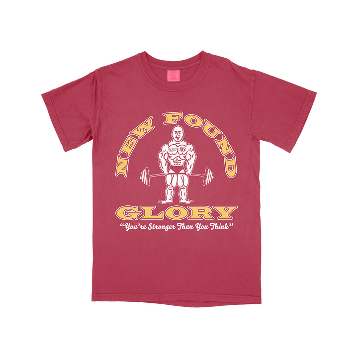 A crimson New Found Glory T-shirt features a cartoon bodybuilder with a barbell, yellow “NEW FOUND” text above, and “GLORY ‘You’re Stronger Than You Think!’” below.
