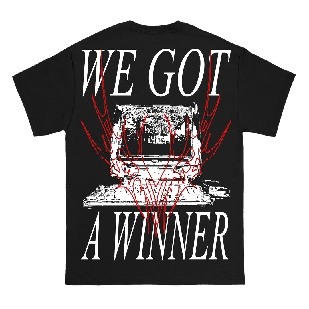 Soulkeeper black T-shirt on Gildan Heavy Cotton with a white glitchy typewriter and red abstract deer skull. Bold white text reads: WE GOT A WINNER above and below the graphic.
