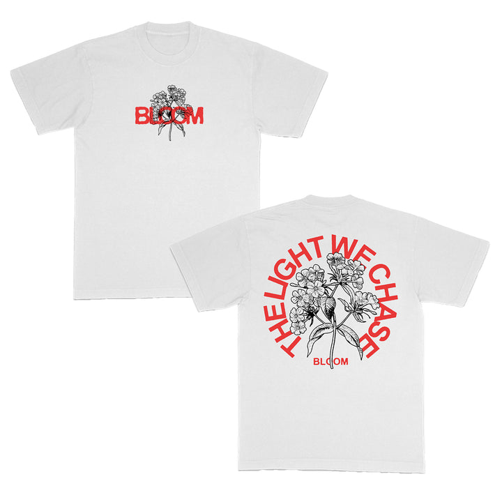 The Bloom white t-shirt features a bold black floral illustration and red BLOOM text on the front; the back displays a large floral design surrounded by THE LIGHT WE CHASE in vivid red lettering.