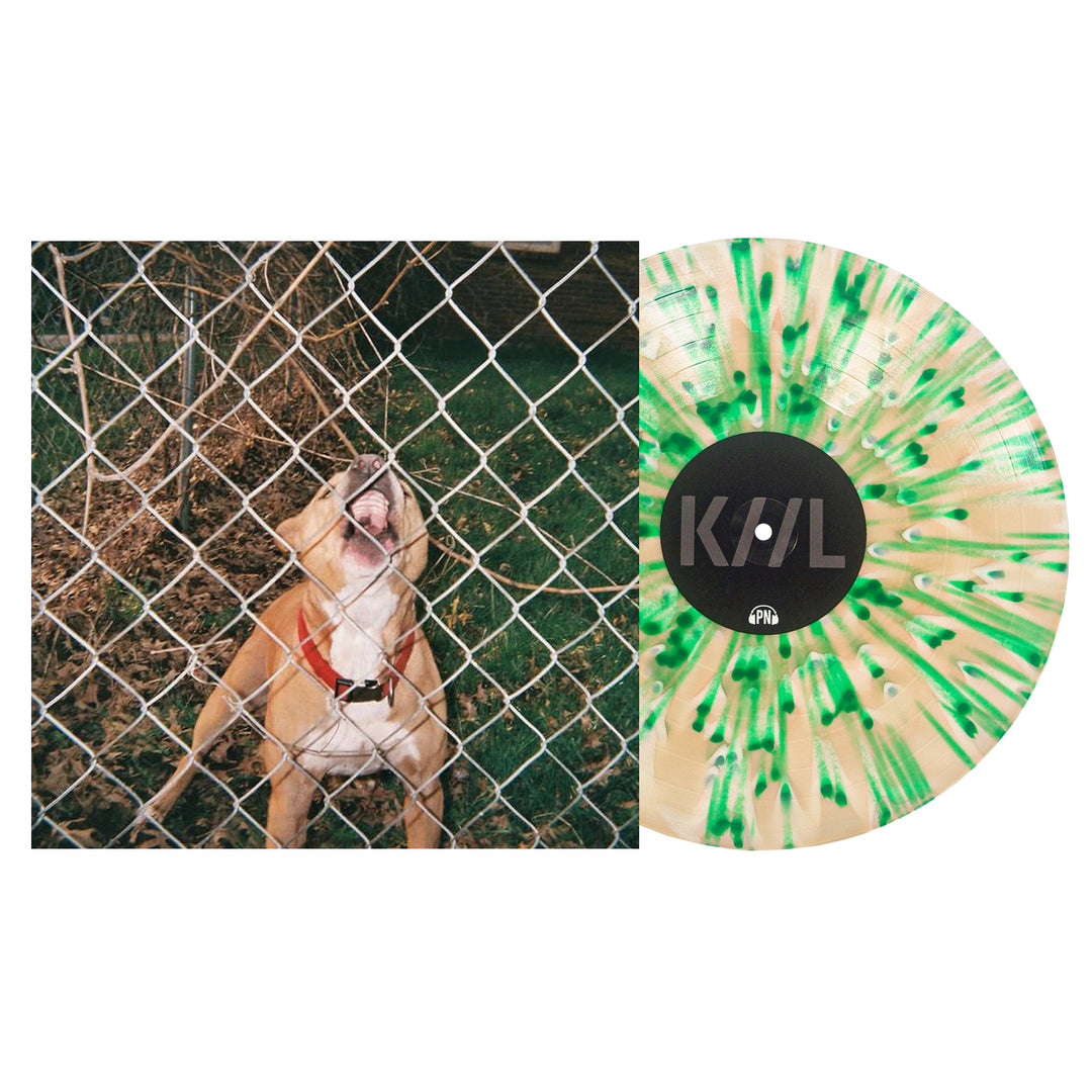 A limited edition Knocked Loose vinyl with green and cream splatter sits beside an album cover of a brown dog with a red collar barking behind a chain-link fence—a must-have for collectors and fans.