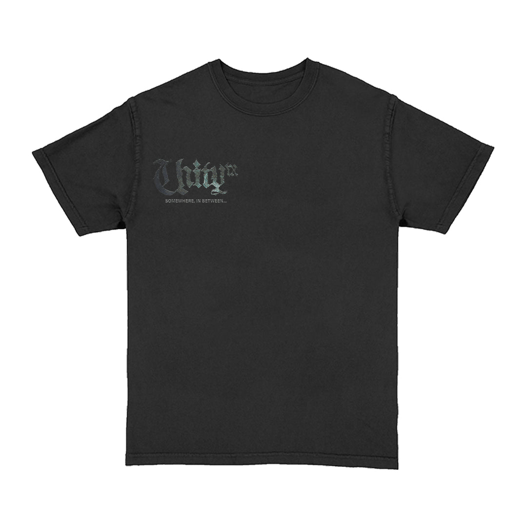 The UNITYTX Comfort Colors t-shirt is plain black, featuring “Thug” in large gray Gothic letters and smaller text “SOMETIME, IN BETWEEN...” on the upper left chest.