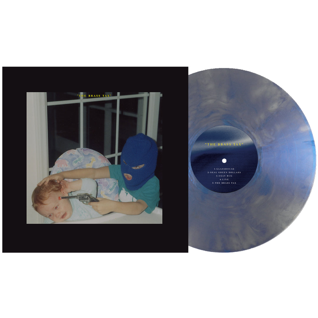 An Iridescent Blue LP from DOWNWARD rests beside its cover, depicting a child in a blue ski mask holding another by a window. The album, The Brass Tax, is now available for vinyl presale—don’t miss out!.