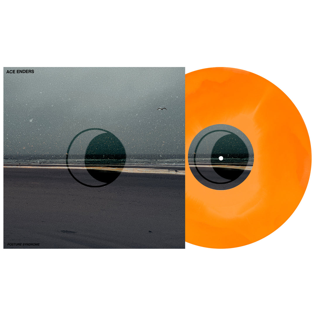 An orange and yellow marbled vinyl record is partially slid out of its Ace Enders album cover, which features a hazy, muted beach scene with minimal text and abstract circular designs.