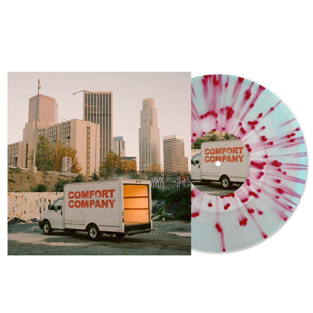 A white vinyl record with pink splatter sits beside an album cover featuring a Comfort Company truck in front of city buildings at sunset. The Bearings Electric Blue Vinyl release is now available for presale.