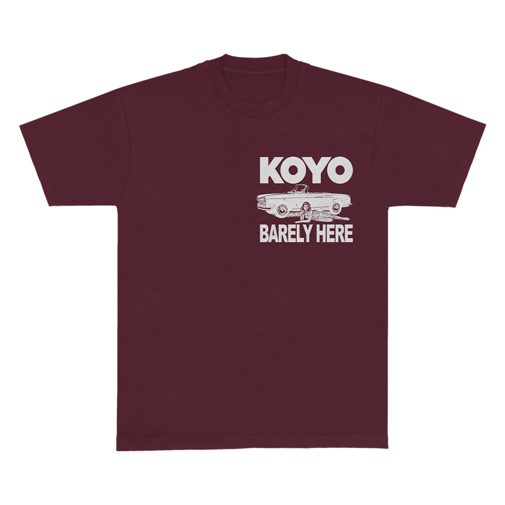 A maroon KOYO t-shirt featuring white “KOYO” text above a vintage car illustration, classic style with low emissions theme, and “BARELY HERE” printed below the car.