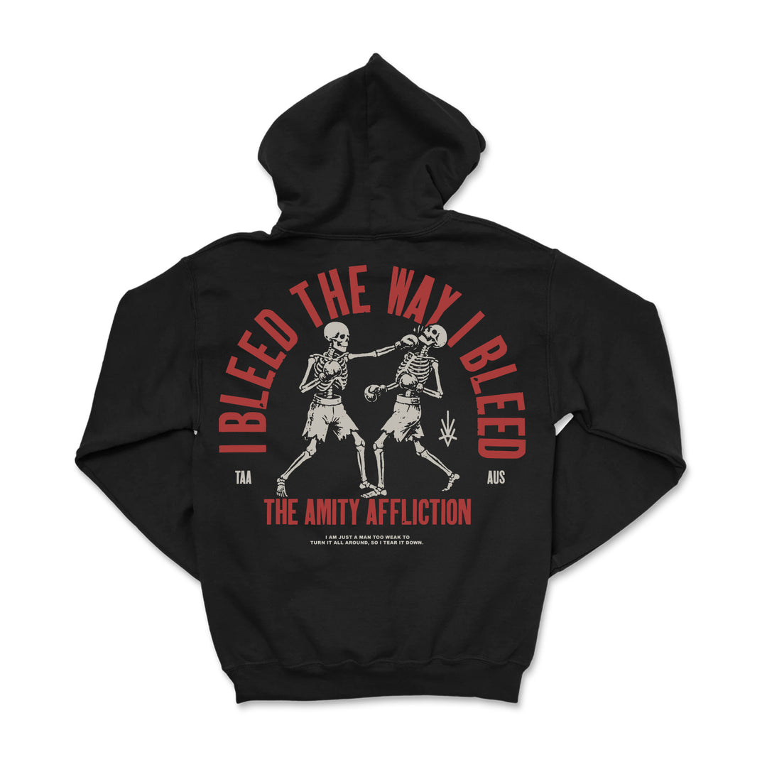 A black Gildan hoodie by The Amity Affliction featuring two skeletons, bold red "I BLEED THE WAY I BLEED" text, orange band name below, and smaller white shirt-style print details underneath.
