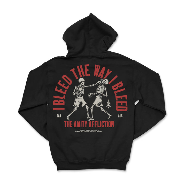 A black Gildan hoodie by The Amity Affliction featuring two skeletons, bold red "I BLEED THE WAY I BLEED" text, orange band name below, and smaller white shirt-style print details underneath.