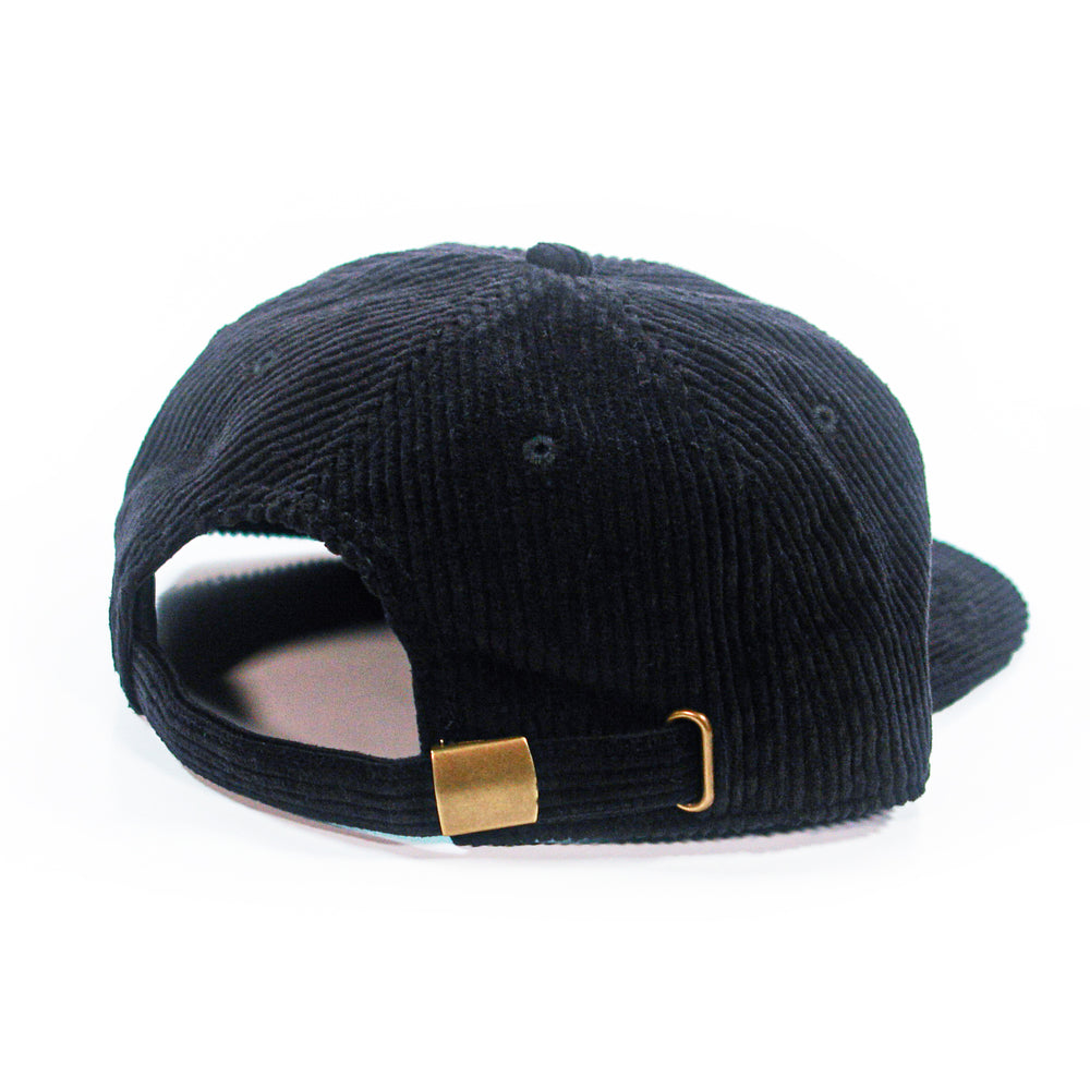 back of a black corduroy cap with a gold buckle on a white background