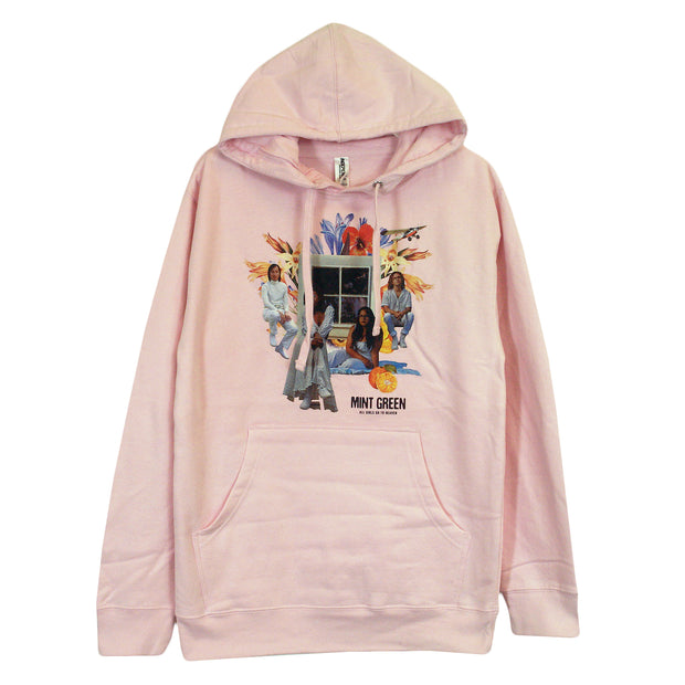 image of the front of a baby pink colored pullover hoodie on a white background. the hoodie has a direct to garment multicolored photograph type print in the center, above the pouch pocket of the band, Mint Green, sitting in front of a window with giant flowers around them.