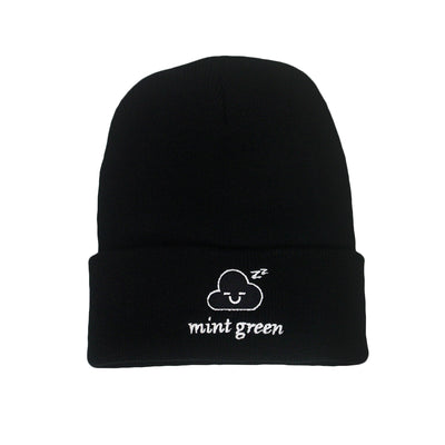 image of a black cuffed winter beanie on a white background. front, center part of the cuff has white embroidery of a cloud face with two Z's at the top, and says mint green below