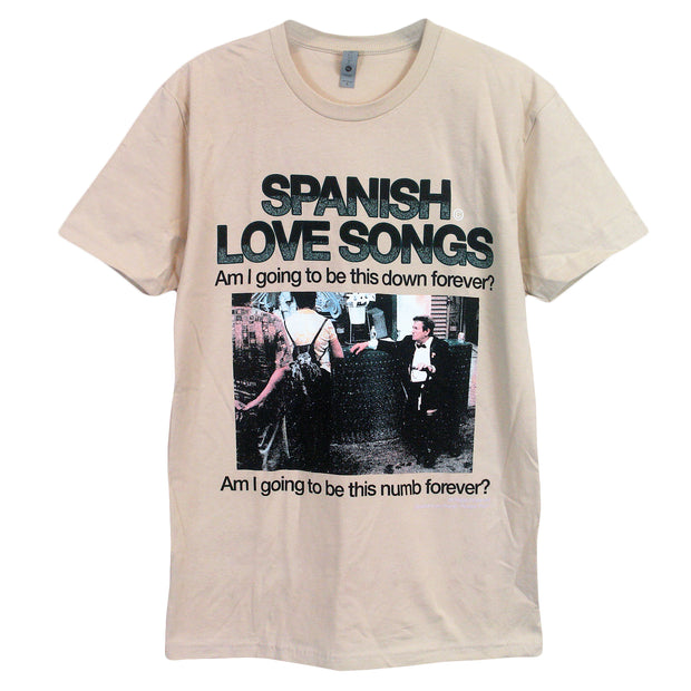 cream colored tshirt on white background.full print over chest of tee. tee has silver tag that says nevel level apparel. below in two tone black and teal font says spanish love songs. below that says am i going to be this down forever? below that is a photo of a man in a suit sitting with two people in front of him with their backs to us, looking at the man. below that says am i going to be this numb forever? texts are in black.