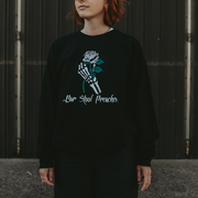 image of a woman wearing a black crewneck sweatshirt. Skeleton hand holding a pink rose with the text Bar Stool Preachers under it on the front