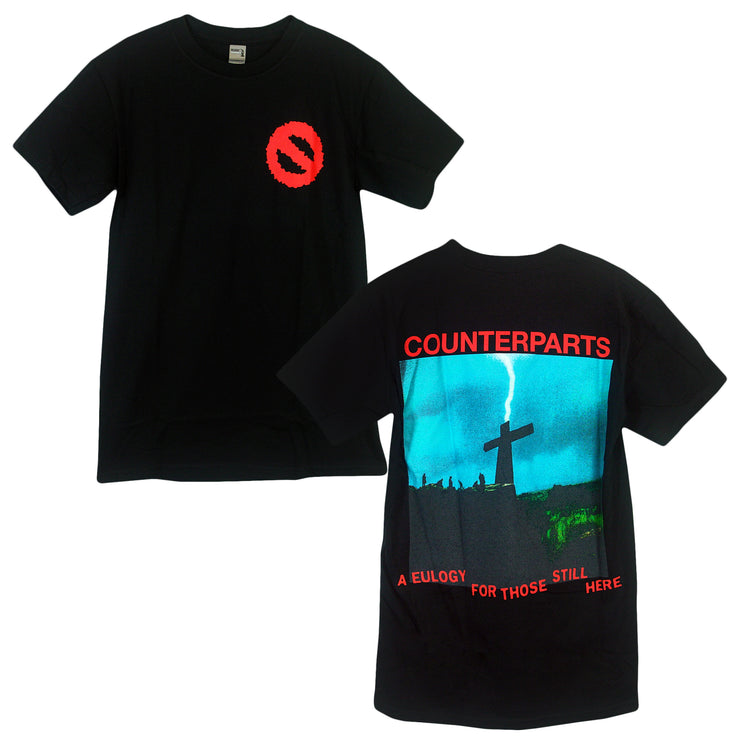 image of black t-shirt to show off prints. front print is the counterparts circle logo on the left chest. Back of t-shirt has the image of a cross in a field with the word "Counterparts" in red ink over it. 