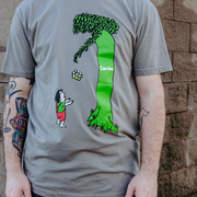 image of a man wearing a grey tee shirt. Samiam Giving Tree Warm Grey T-Shirt. front of t-shirt if parody of the giving tree book cover with the tree giving a 6 pack to a man. 