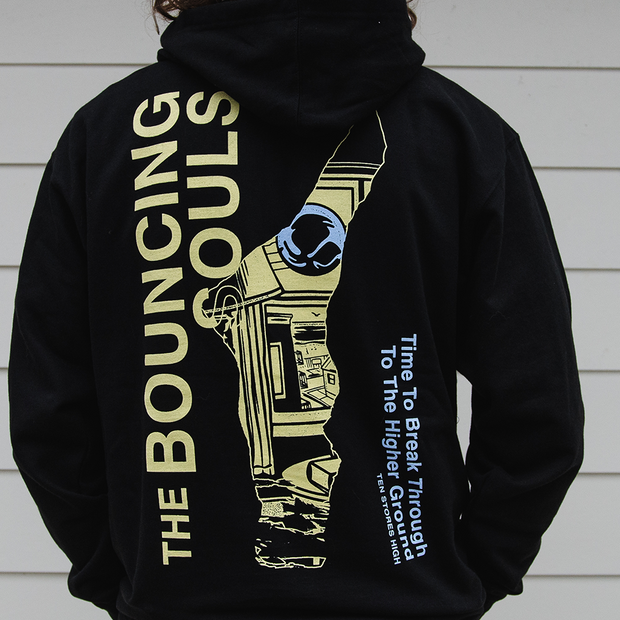 image of the back of a man wearing a black pullover hoodie that has "The Bouncing Souls" text in yellow, "Time to break through the higher ground, Ten Stories High" text in blue. And a odd shaped cut out in the center of the back with the album art peering through.