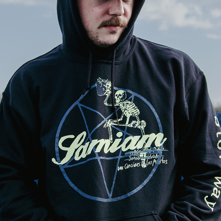image of a man wearing a black pullover hoodie. . front of pullover has a pentagram with "Samiam" printed in yellow in the center of pentagram. A skeleton has its foot leaning on the word samiam with a beer glass raised