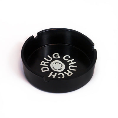 image of a black ashtray on a white background. in the center of the ashtray says drug church around a blob in white.