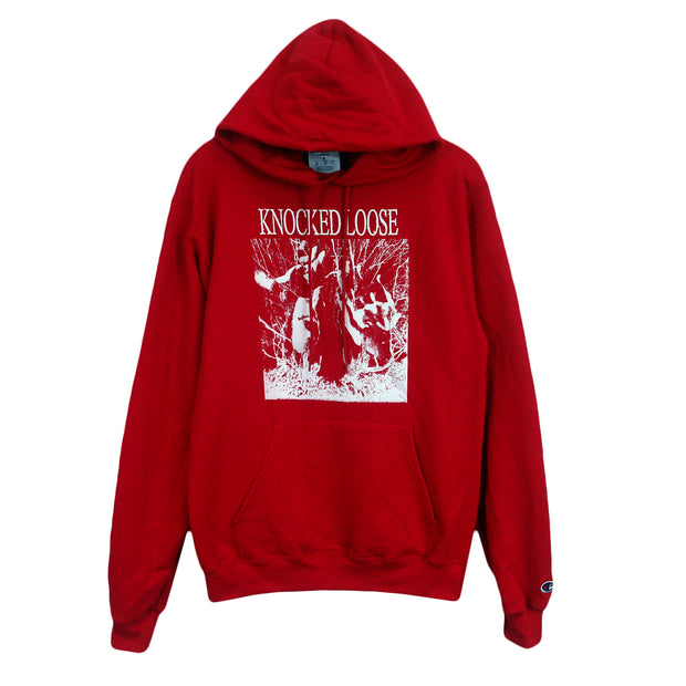 image of the front of a red pullover hooded sweatshirt on a white background.  Hoodie has a full chest print in white. above the front pouch pocket. Knocked loose is written at the top and below that is an image of a persons face with sunglasses on and hands up with white scribbles surrounding it.