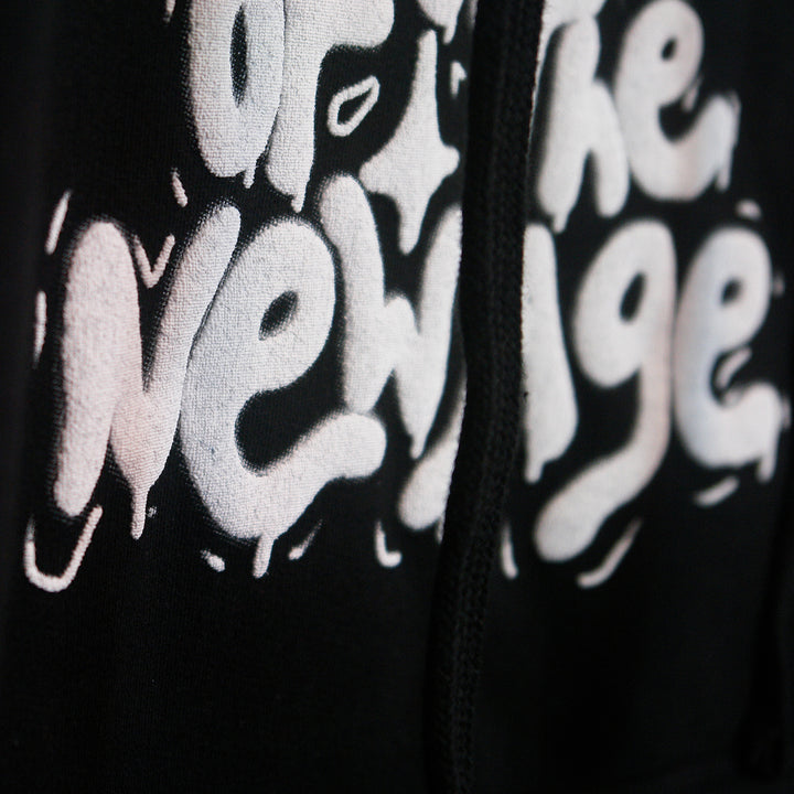 close up image of the white puff print on a black hoodie.