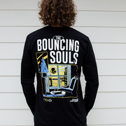 image of the back of a man wearing a black long sleeve tee shirt. the back of the Long Sleeve is the albums cover art which depicts a person sitting by the window looking out to the city to see the bouncing souls symbol in the sky