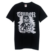 image of the front of a black tee shirt on a white background. the tee has a center chest print in white. the top says terror, and then a skeleton in front of a brick wall with demons. the bottom says the walls will fall.