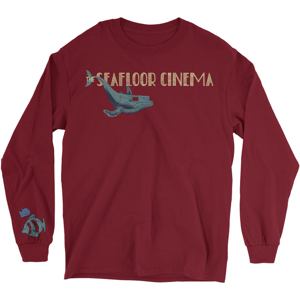 The Seafloor Cinema Garnet Long Sleeve. The center chest print of the shirt is the text The Seafloor Cinema with a whale wearing 3D glasses under the text. the right sleeve has two fish by the cuff.