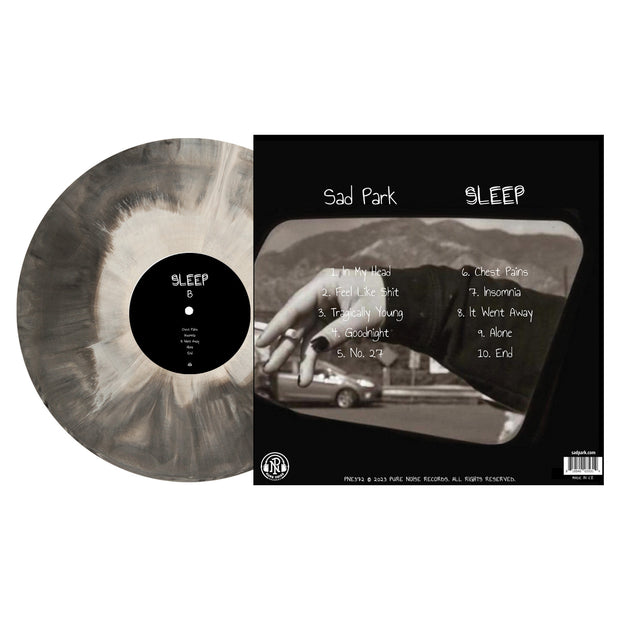 Side B of Sad Parks "Sleep" Vinyl LP with vinyl exposed to show color. color of LP is black and white galaxy mix. back of LP album art is a close up of a hand holding a cigarette with some hills in the background. 